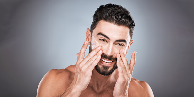 Man using a Pevonia moisturizer on his face.