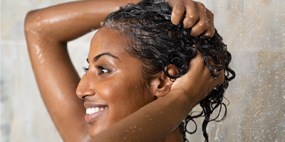 A woman washing her hair in the shower.