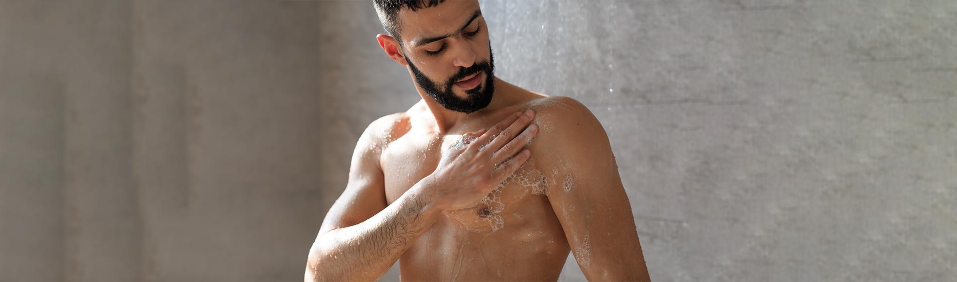 Man cleansing himself with Pevonia's Bath & Body product in the shower.