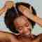 A woman applying Pevonia's Hair Energize Extra-Strength Overnight Serum.